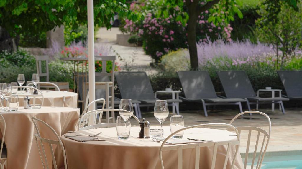 a group of tables and chairs with wine glasses at Hôtel La Figuière in Saint-Tropez