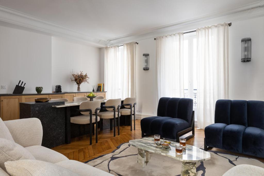 un salon avec une table et des chaises dans l'établissement Champs Élysées Montaigne Luxury 2 bedroom, à Paris