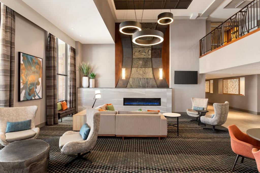 ein Wohnzimmer mit einem Sofa, Stühlen und einem Kamin in der Unterkunft Holiday Inn Hotel &amp; Suites Council Bluffs by IHG in Council Bluffs