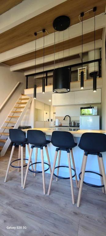 une cuisine avec une table et des chaises ainsi qu'un escalier dans l'établissement très bel appartement refait entierement a neuf !, au Cap d'Agde