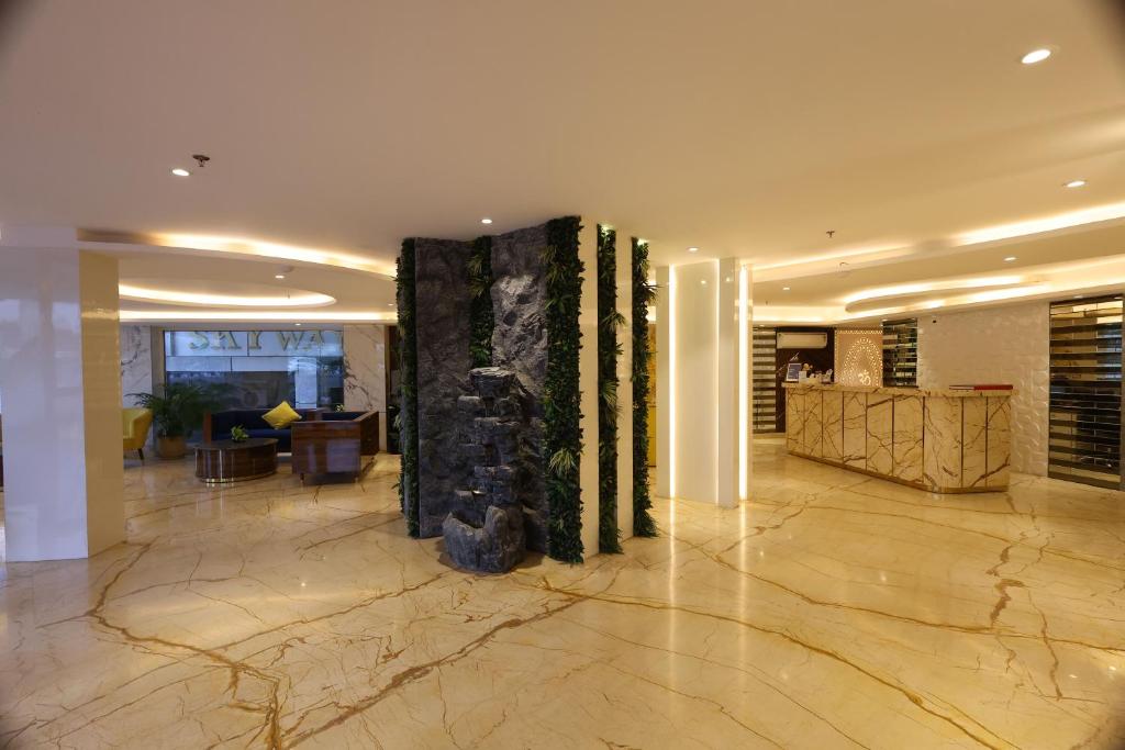 um lobby com uma grande coluna no meio de um edifício em Airport Hotel Ramhan Palace Mahipalpur em Nova Deli