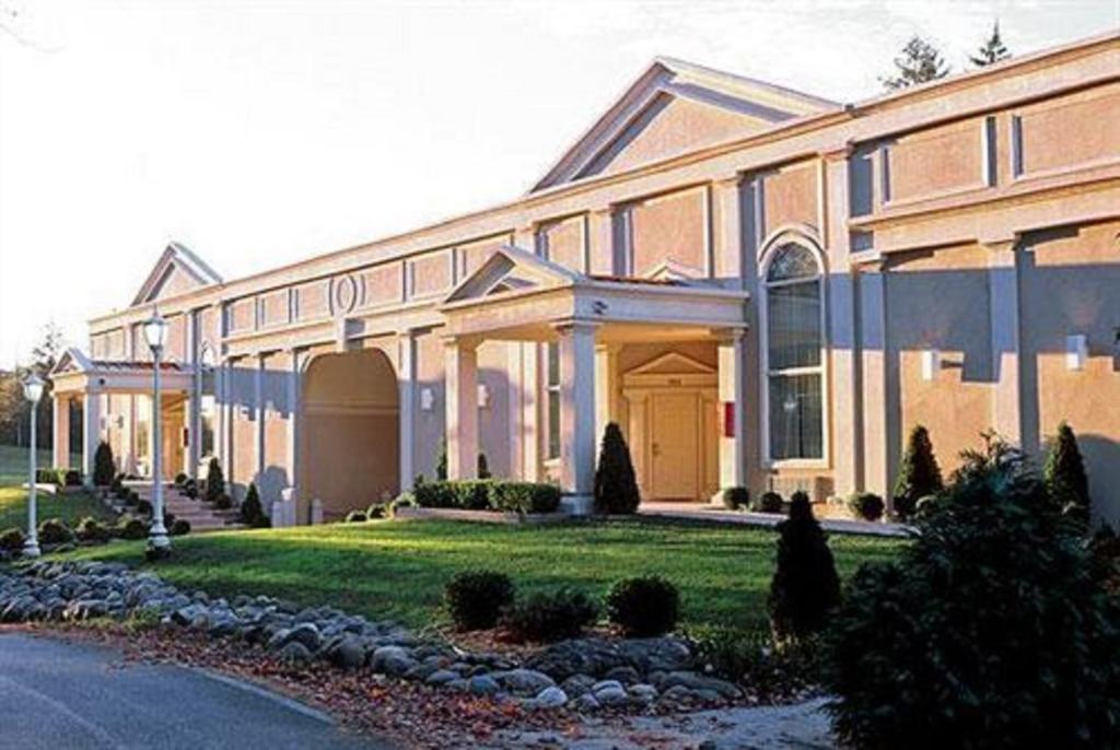 un grand bâtiment en briques avec une pelouse devant lui dans l'établissement Pocono Palace Resort, à East Stroudsburg