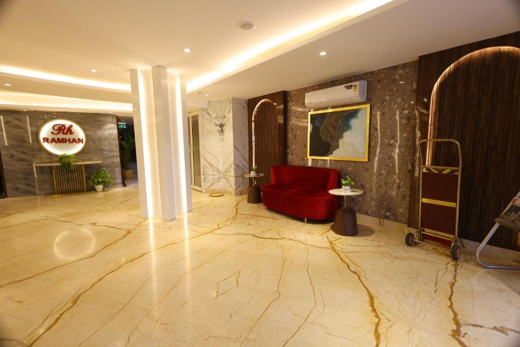 um átrio com uma cadeira vermelha e um sofá vermelho em Airport Hotel Ramhan Palace Mahipalpur em Nova Deli