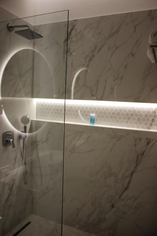 a bathroom with a shower with a glass door at Hotel Monarch in Elbasan