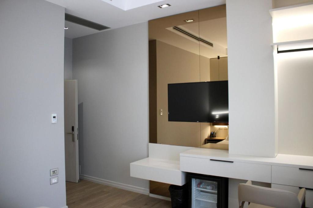 a living room with a large mirror and a tv at Hotel Monarch in Elbasan