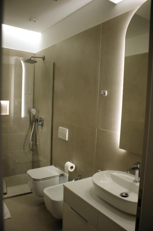 a bathroom with a toilet and a sink and a shower at Hotel Monarch in Elbasan