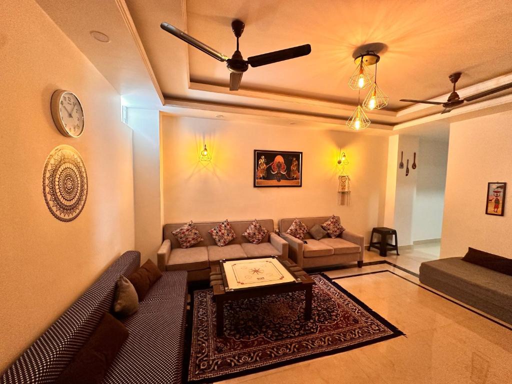 a living room with a couch and a ceiling fan at Yoga Retreat at The Ganges in Rishikesh in Rishīkesh