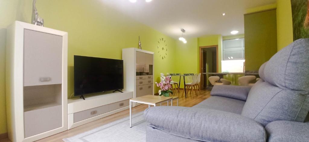 a living room with a blue chair and a television at Reivi Vilanova de Arousa in Villanueva de Arosa