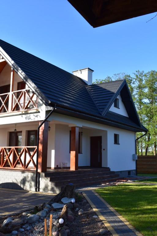 Skazdub StarySummer house in Suwalszczyzna- Dom w Dolinie Rospudy的一栋带有黑色屋顶的白色房子