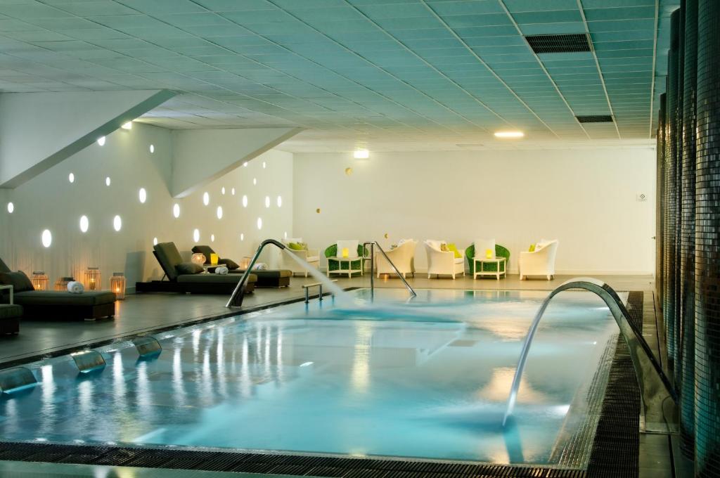 uma grande piscina num quarto de hotel em Open Village Sports Hotel & Spa Club em Guimarães