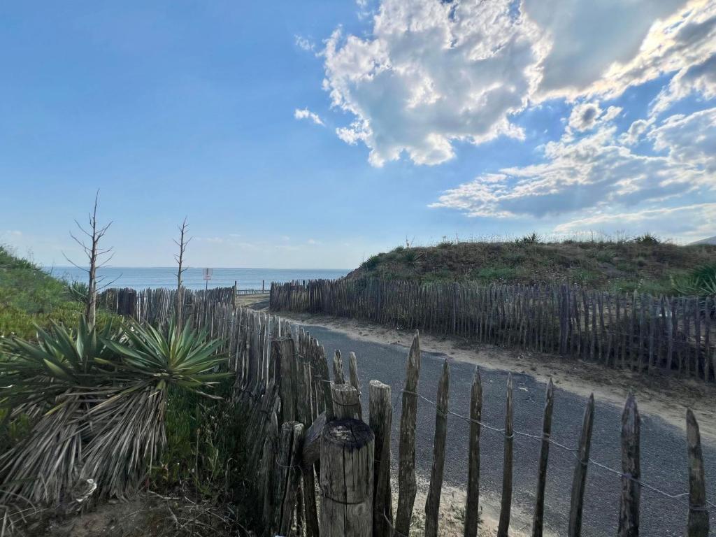 une clôture sur le côté d'une route près de l'océan dans l'établissement Logement avec accès direct à la mer à La Tranche-sur-Mer, à La Tranche-sur-Mer