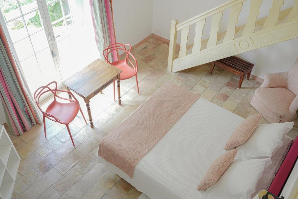 a bedroom with a bed and a table and chairs at Hôtel La Figuière in Saint-Tropez