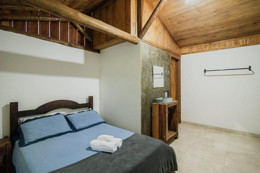 una camera da letto con un letto con due asciugamani sopra di Pousada Passaredo a Brumadinho