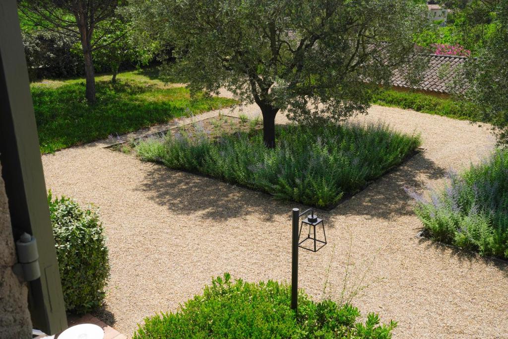 a garden with a bird feeder in the middle at Hôtel La Figuière in Saint-Tropez