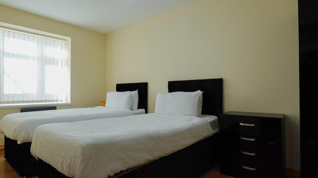 Dos camas una al lado de la otra en un dormitorio. en The ComfortGrove Apartment, en Mánchester