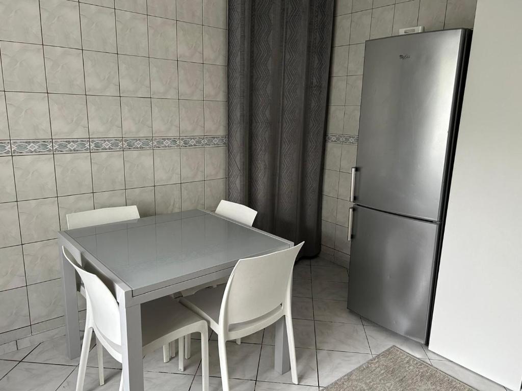 une cuisine avec une table et un réfrigérateur dans l'établissement Coccinelle, à Montataire