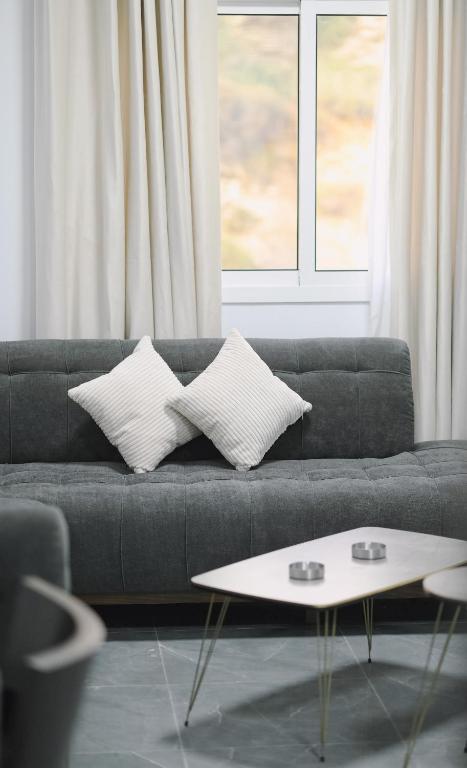 a living room with a couch with pillows and a table at Chouf View Residence in Baddah