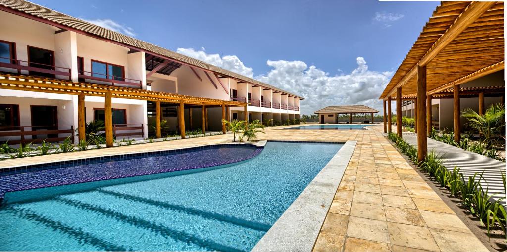 a swimming pool in front of a building at Tabaobí Smart Hotel in Porto De Galinhas