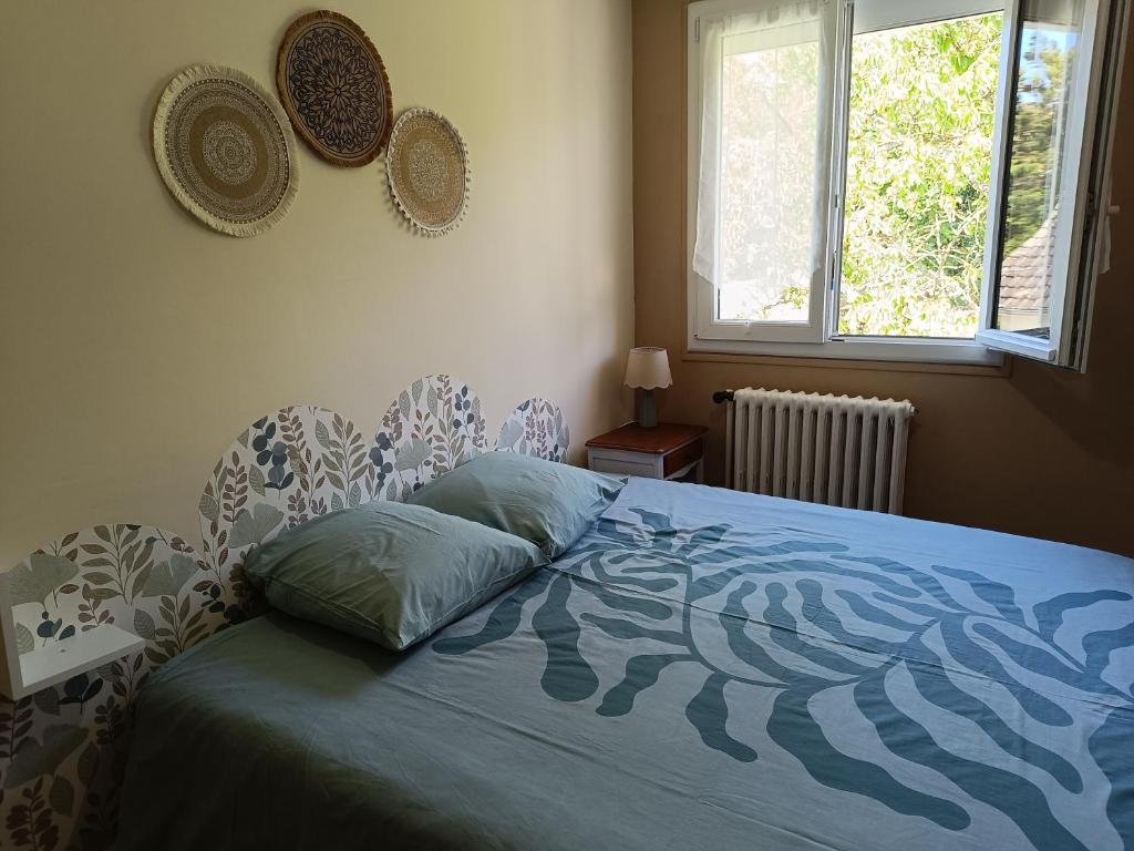 a bedroom with a bed with a blue comforter at La Maison de LULU proche baie de Somme in Eu
