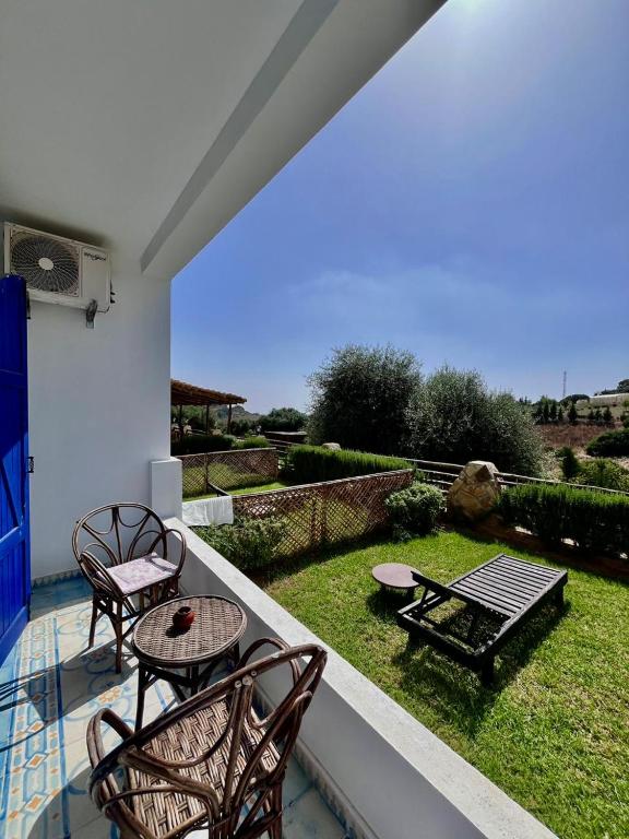 a patio with two chairs and a table on a balcony at Dmina House in Asilah