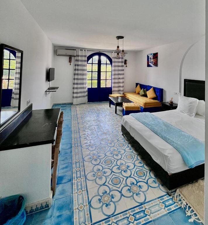 a bedroom with a bed and a living room at Dmina House in Asilah