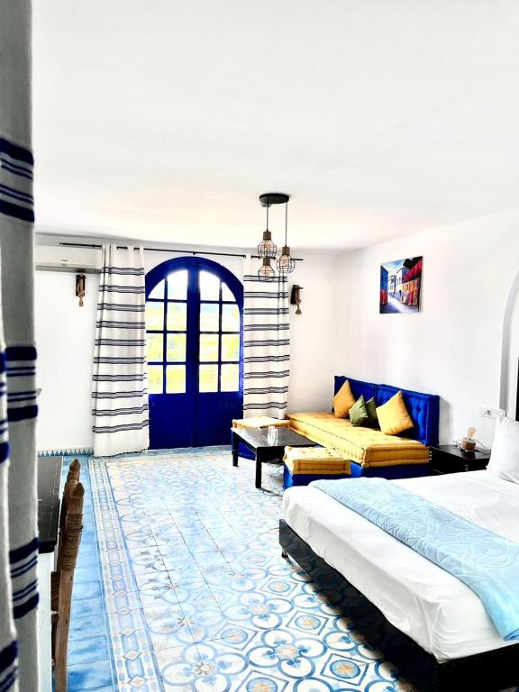 a bedroom with a bed and a couch at Dmina House in Asilah