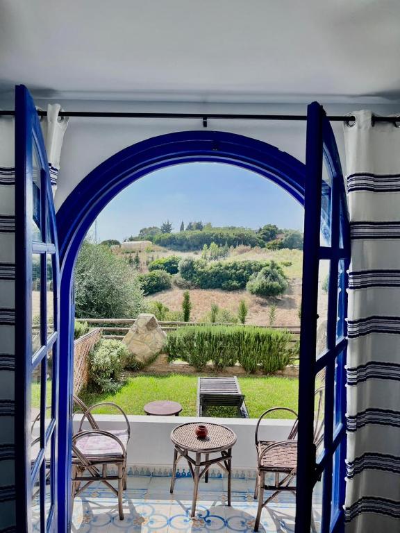 an open door to a patio with a table and chairs at Dmina House in Asilah