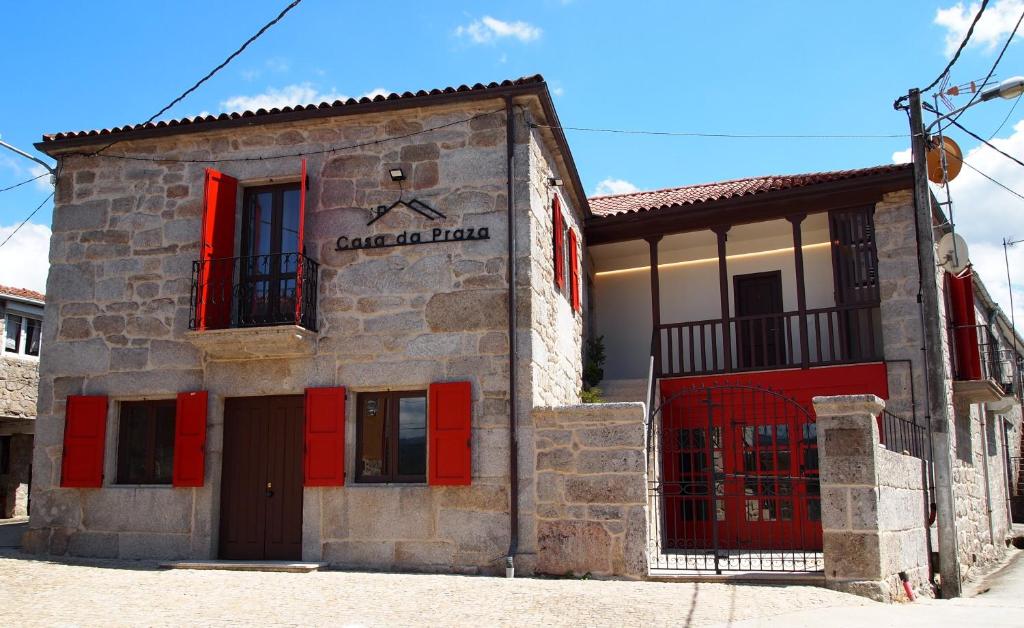 a building with red doors and a sign on it at Casa da Praza in Lobios