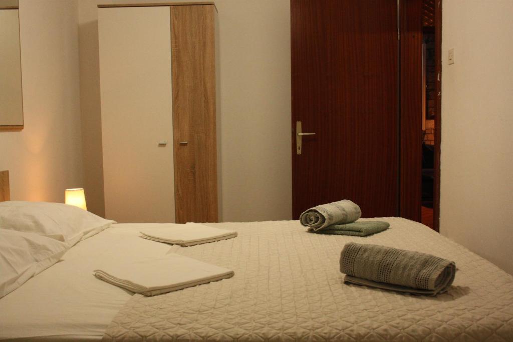 a white bed with two towels on top of it at Apartment Ivan in Račišće