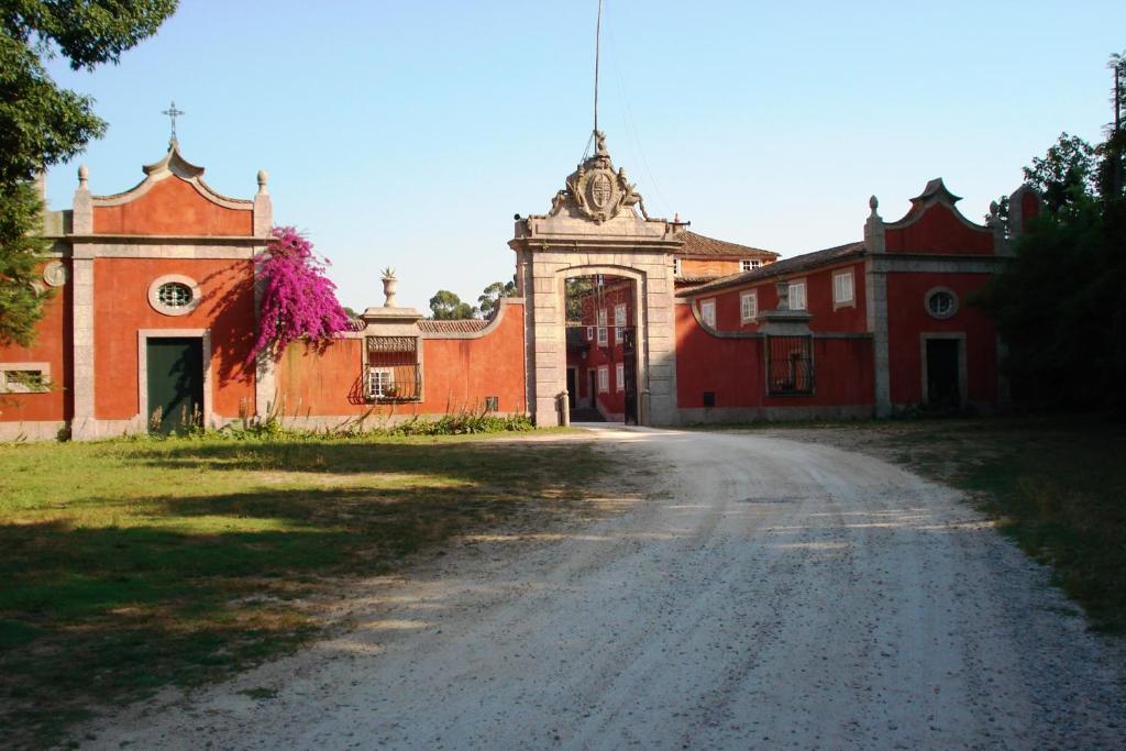 an empty road in front of a red building at Casa de Sezim in Guimarães