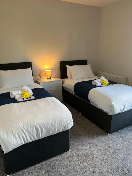 a room with two beds with flowers on them at Gemini 1 in Great Wyrley