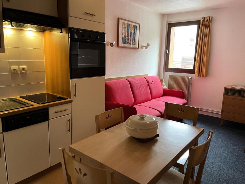 une cuisine et une salle à manger avec une table et un canapé rose dans l'établissement LE CHALET - Piscine 12 - Studio pour 4 Personnes MAE-8724, à Gourette
