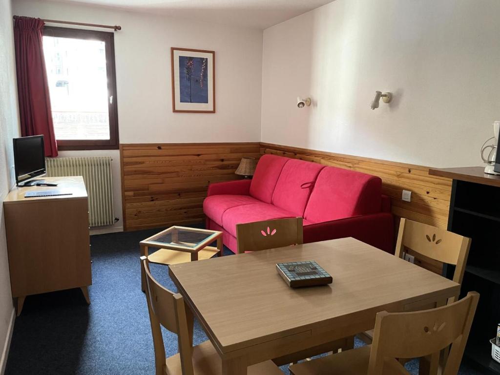 un salon avec un canapé rouge et une table dans l'établissement LE CHALET - Piscine 13 - Studio pour 4 Personnes MAE-8744, à Gourette