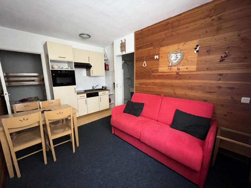 un salon avec un canapé rouge et une cuisine dans l'établissement LE CHALET - Piscine 6 - Studio pour 4 Personnes MAE-8754, à Gourette