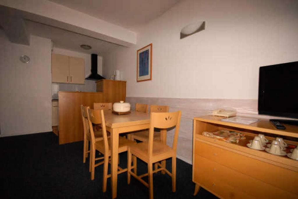 une cuisine avec une table et des chaises et une télévision dans l'établissement LE CHALET - Piscine 7 - 2 Pièces pour 6 Personnes MAE-8834, à Gourette