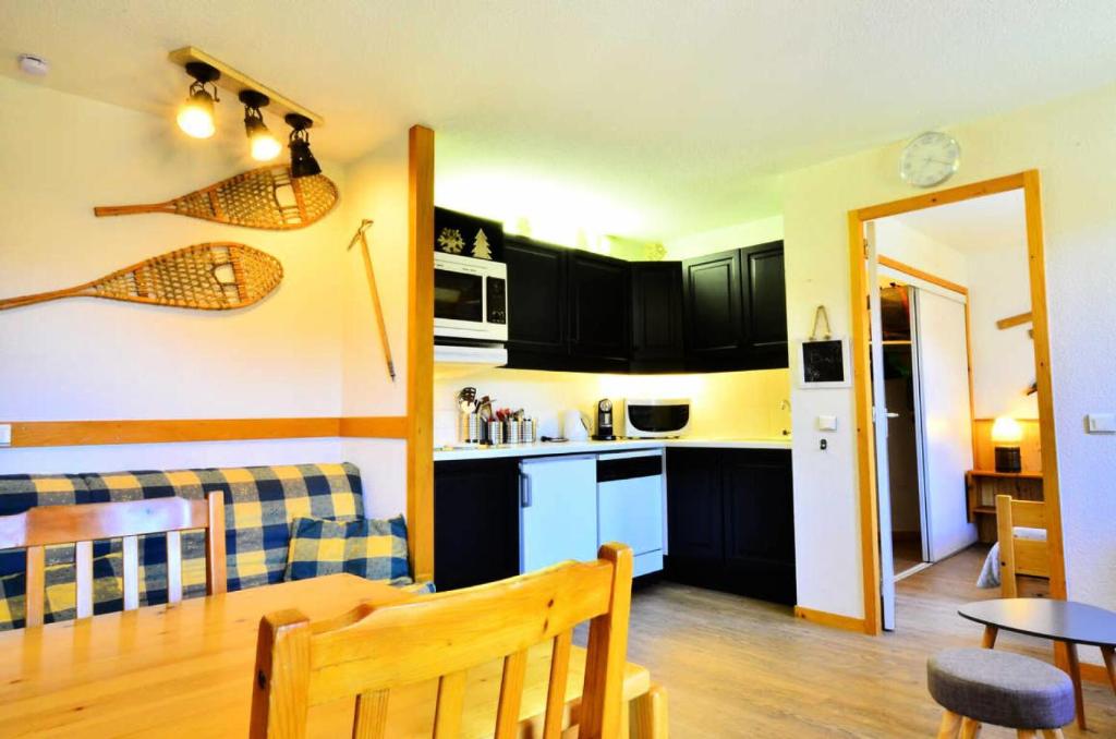 une cuisine et un salon avec une table, une cuisine et une salle à manger dans l'établissement Résidence LE TETRAS LYRE - 2 Pièces pour 5 Personnes MAE-9494, à Aime La Plagne