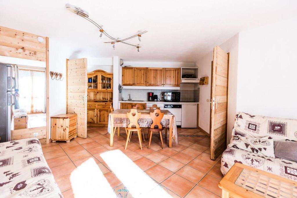 une cuisine et un salon avec une table et des chaises dans l'établissement Résidence LE TETRAS LYRE - 2 Pièces pour 6 Personnes MAE-0134, à Aime La Plagne