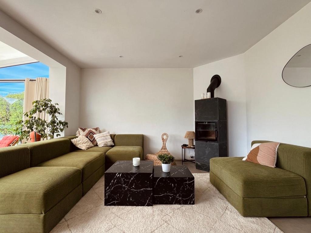 un salon avec un canapé vert et une table dans l'établissement BonAir s House La Maison du Bon Air, à Wimereux