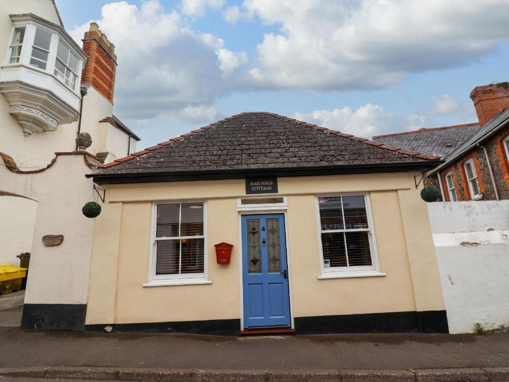 a small house with a blue door on a street at Hardings cottage in Minehead