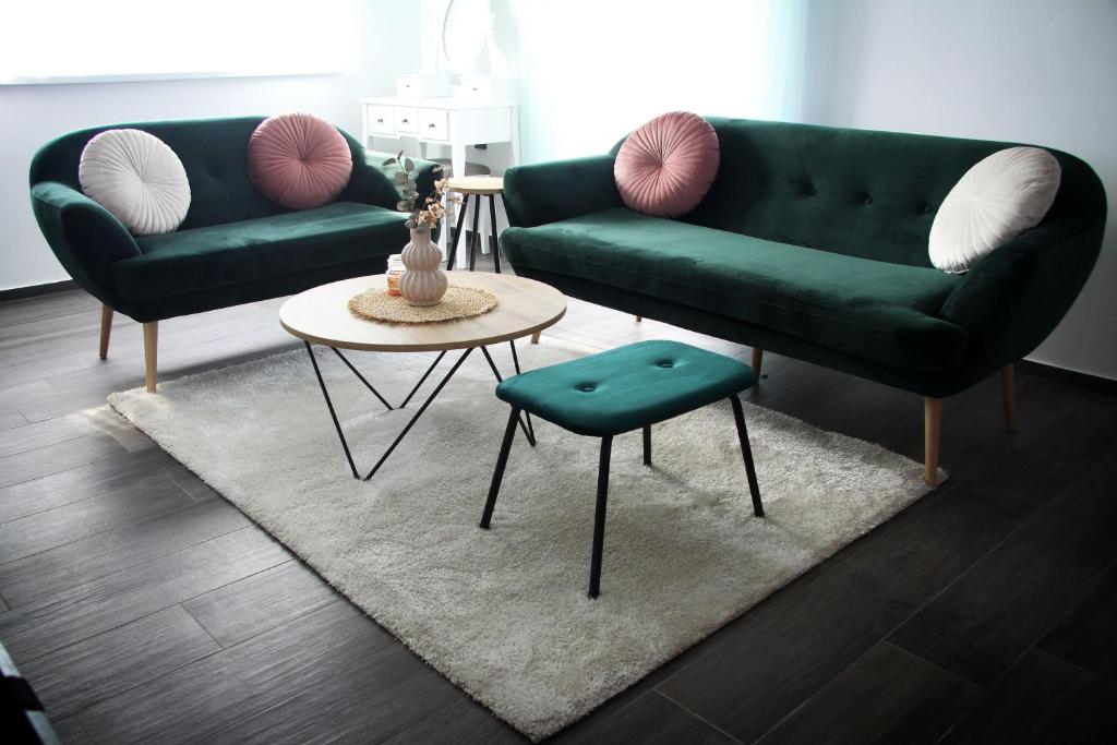 a living room with two green couches and a table at Apartman Matulica in Čakovec