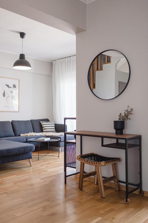 a living room with a blue couch and a mirror at NIMA Village in Paleros