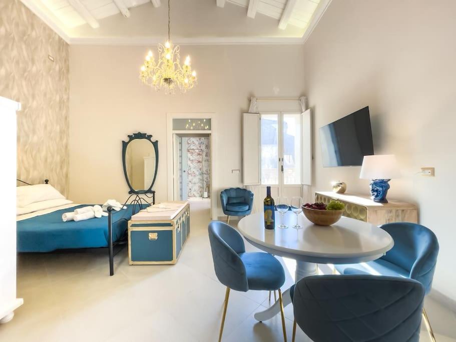 una stanza con un letto, un tavolo e delle sedie di Apollo & Artemide Suite a Siracusa