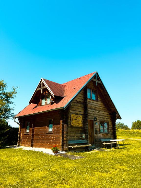a wooden house with a red roof in a field at Haus Lahneck bei Koblenz in Lahnstein