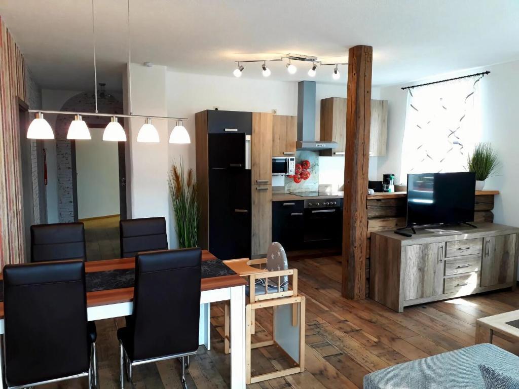 a living room with a dining table and a kitchen at I "Old School" Comfortable holiday residence in Reinhardtsdorf