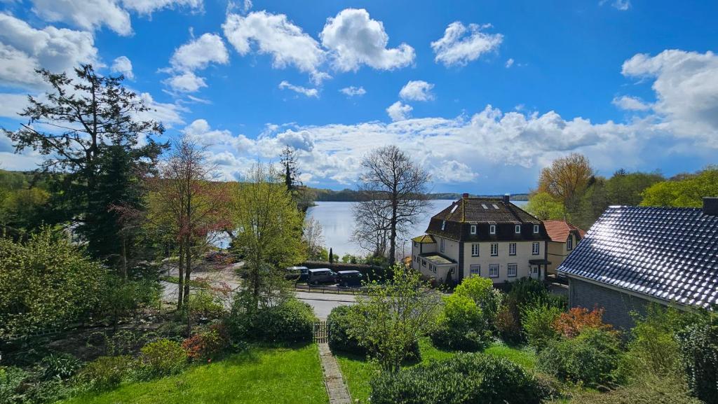 a view of a house with a lake in the background at Altes Seeblickjuwel in Eutin