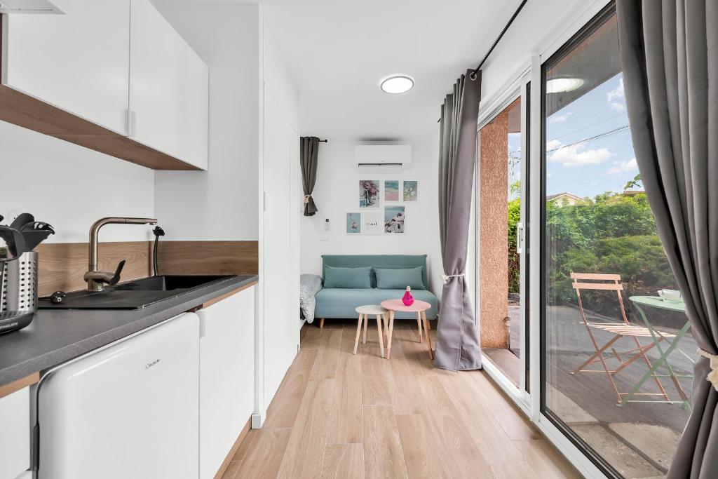 a kitchen with a sink and a table with a chair at L Atmosphère Tendre in Toulouse