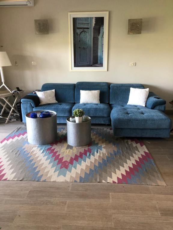 a living room with a blue couch and a rug at 4 bedrooms 4 bathrooms Villa at the beautiful Ghazala Bay- North Coast - Egypt in Dawwār Abū Maḩrūs