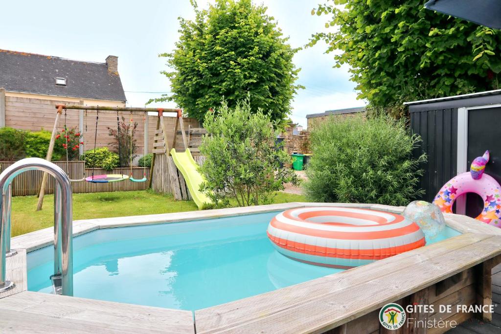 a swimming pool with a toy in a backyard at Magnifique demeure à 15 min des plages 12 adultes in Saint-Renan