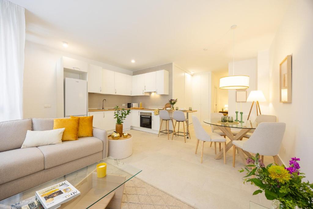 a living room and kitchen with a couch and a table at Vallecas Apartments in Madrid