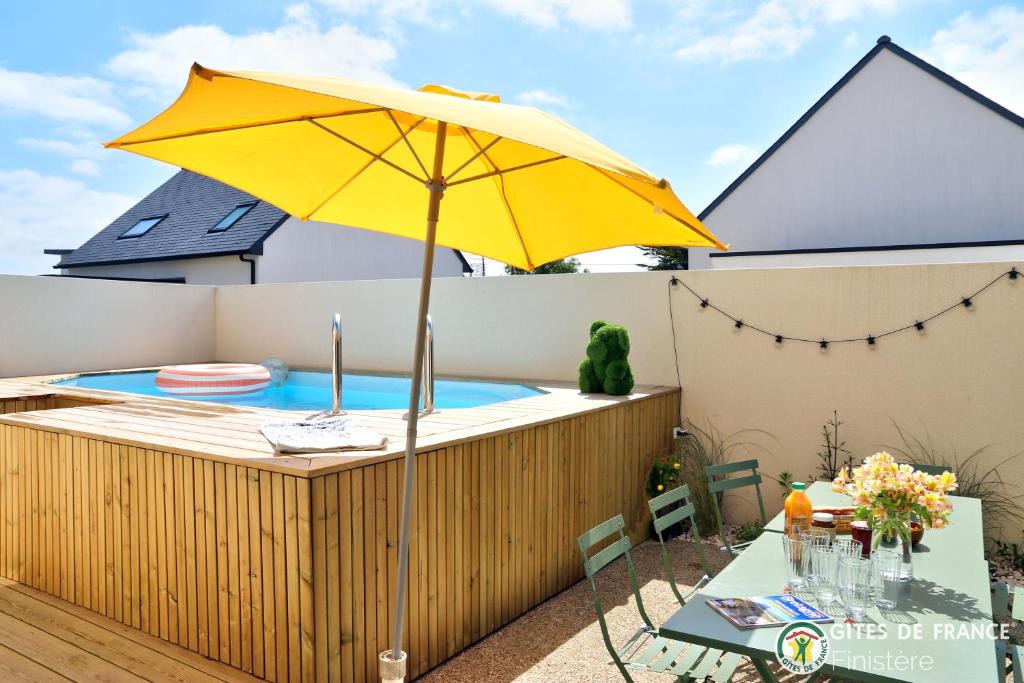 un parasol jaune assis à côté d'une piscine dans l'établissement 4 minutes à pieds de la plage., au Conquet